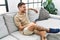 Young hispanic man smiling confident using smartphone at home