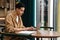 Young hispanic man student sitting at the cafe table indoors