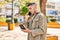 Young hispanic man talking on the smartphone reading passport at park