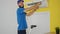 Young hispanic man technician repairing air condition machine standing on ladder at home