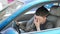 Young hispanic man tired driving car yawning at street