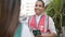 Young hispanic man volunteer speaking with person at street