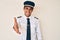 Young hispanic man wearing airplane pilot uniform smiling friendly offering handshake as greeting and welcoming