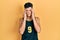 Young hispanic man wearing basketball uniform with hand on head for pain in head because stress