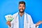 Young hispanic man wearing doctor uniform holding israel shekels celebrating achievement with happy smile and winner expression