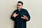 Young hispanic man wearing priest uniform standing over white background disgusted expression, displeased and fearful doing