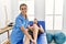 Young hispanic physioterapist woman make ankle rehab treatment to man at the clinic