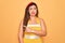Young hispanic pin up woman wearing fashion sexy 50s style over yellow background Pointing aside worried and nervous with