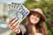 Young hispanic tourist woman smiling happy holding romania lei banknotes at the city