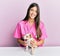 Young hispanic veterinarian girl smiling happy examining little dog at the clinic