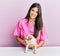 Young hispanic veterinarian girl smiling happy examining little dog at the clinic