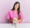 Young hispanic veterinarian girl smiling happy examining little dog at the clinic