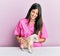 Young hispanic veterinarian girl smiling happy examining little dog at the clinic