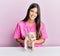 Young hispanic veterinarian girl smiling happy examining little dog at the clinic
