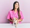 Young hispanic veterinarian girl smiling happy examining little dog at the clinic