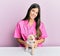 Young hispanic veterinarian girl smiling happy examining little dog at the clinic