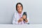 Young hispanic veterinary girl examining cat using stethoscope at the clinic