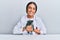 Young hispanic veterinary girl smiling happy holding cat working at the clinic