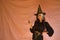 Young Hispanic woman dressed as a witch pointing finger on pink background for halloween