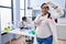 Young hispanic woman expecting a baby working at scientist laboratory smiling making frame with hands and fingers with happy face