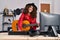 Young hispanic woman musician composing song playing classical guitar at music studio