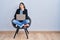 Young hispanic woman sitting on chair using computer laptop bored yawning tired covering mouth with hand