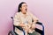 Young hispanic woman sitting on wheelchair angry and mad screaming frustrated and furious, shouting with anger