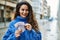 Young hispanic woman smiling happy counting sweden krone banknotes at the city