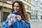 Young hispanic woman smiling happy counting sweden krone banknotes at the city