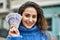 Young hispanic woman smiling happy holding sweden krone banknotes at the city