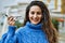 Young hispanic woman smiling happy plane toy at the city