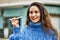 Young hispanic woman smiling happy plane toy at the city