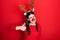 Young hispanic woman wearing deer christmas hat and red nose doing happy thumbs up gesture with hand