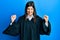 Young hispanic woman wearing judge uniform celebrating surprised and amazed for success with arms raised and open eyes