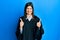 Young hispanic woman wearing judge uniform success sign doing positive gesture with hand, thumbs up smiling and happy