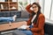 Young hispanic woman working as psychology counselor smiling confident touching hair with hand up gesture, posing attractive and