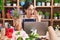 Young hispanic woman working at florist shop doing video call shouting and screaming loud to side with hand on mouth