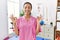 Young hispanic woman working at pain recovery clinic relax and smiling with eyes closed doing meditation gesture with fingers