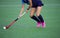 Young hockey player woman with ball in attack playing field hockey game