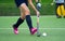 Young hockey player woman with ball in attack playing field hockey game