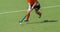 Young hockey player woman with ball in attack playing field hockey game