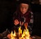 Young homeless boy warming by the newspapers fire