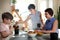 A young homosexual lesbian family with two children, a boy and a girl, at home in the kitchen forgiving the windows