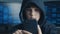 Young hooded boy using a smartphone device. Portrait of Genius boy wonder hacks system at cyberspace.