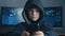 Young hooded hacker kid using a smartphone device to hijack. Genius boy wonder hacks system at cyberspace.