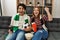 Young hooligan couple supporting soccer team sitting on the sofa at home