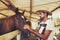 Young horse breeder comforting a horse in stable.