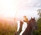 Young horseback girl shooting arrow from bow