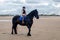 Young horsewoman galloping on the beach in northern France