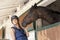 Young horsewoman with its horses in the stable